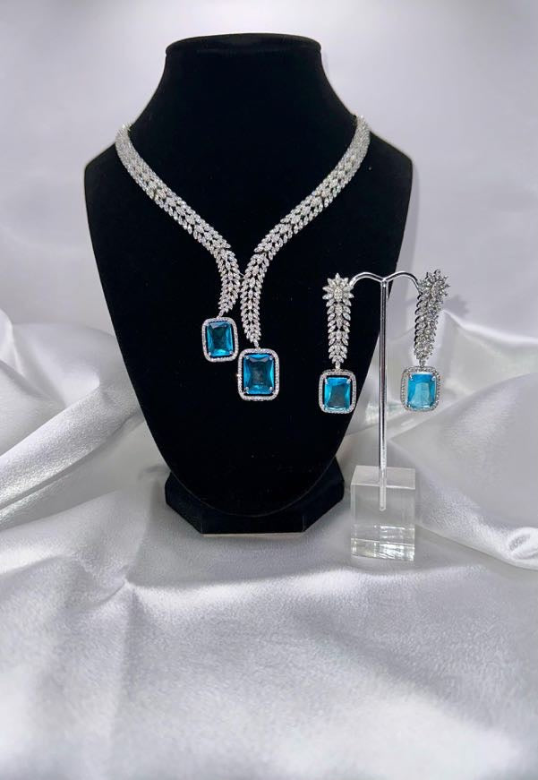 Elegant set features a dazzling V-shaped necklace and matching drop earrings.